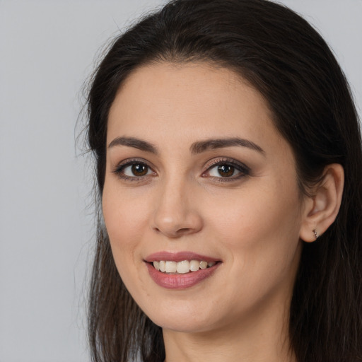 Joyful white young-adult female with long  brown hair and brown eyes