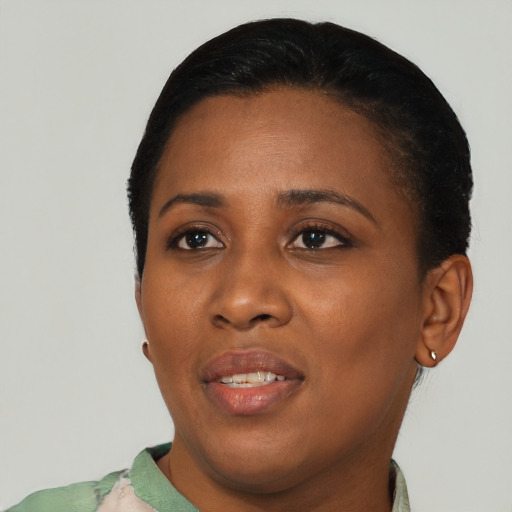 Joyful black young-adult female with short  black hair and brown eyes