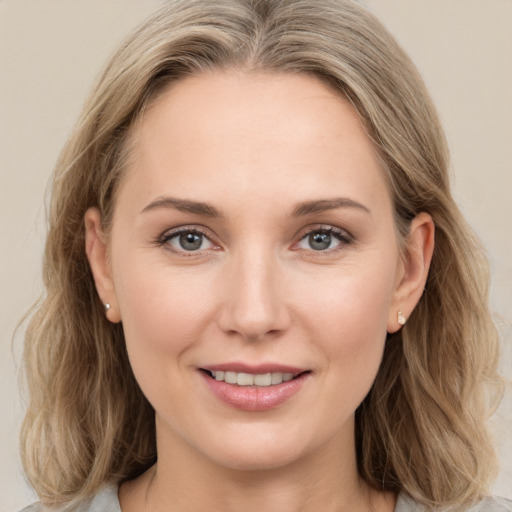 Joyful white young-adult female with medium  brown hair and grey eyes