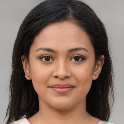 Joyful latino young-adult female with medium  brown hair and brown eyes