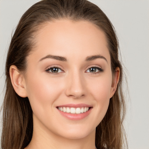 Joyful white young-adult female with long  brown hair and grey eyes