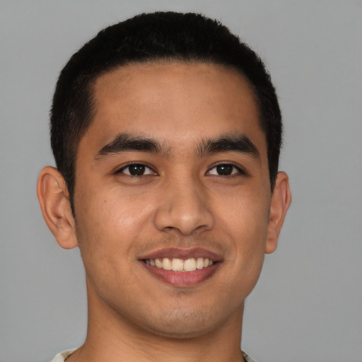 Joyful latino young-adult male with short  brown hair and brown eyes