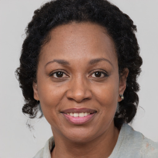 Joyful black adult female with medium  brown hair and brown eyes