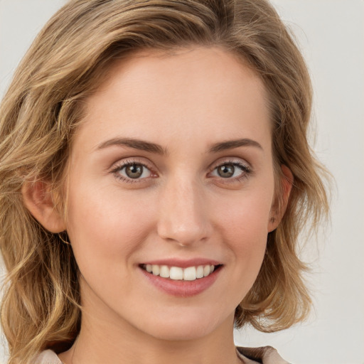 Joyful white young-adult female with medium  brown hair and green eyes