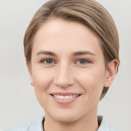 Joyful white young-adult female with short  brown hair and grey eyes