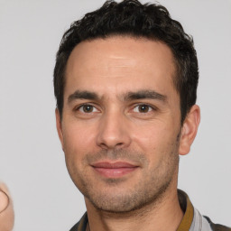 Joyful white young-adult male with short  black hair and brown eyes