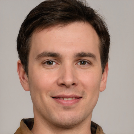 Joyful white young-adult male with short  brown hair and grey eyes