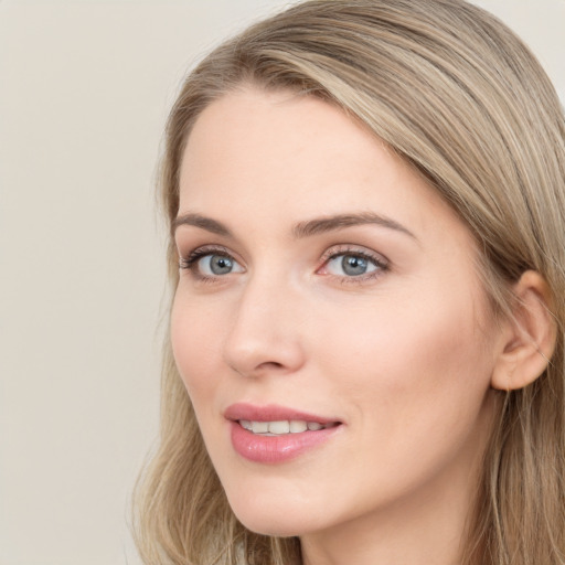 Joyful white young-adult female with long  brown hair and blue eyes