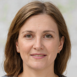 Joyful white young-adult female with medium  brown hair and green eyes