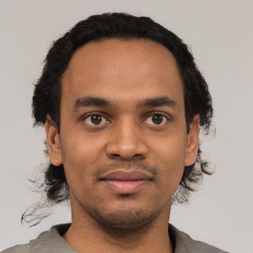 Joyful black young-adult male with short  black hair and brown eyes