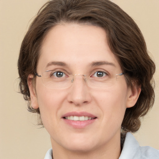 Joyful white adult female with medium  brown hair and green eyes