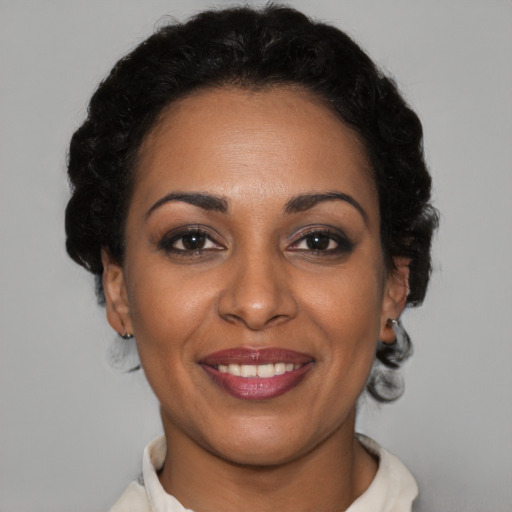 Joyful black adult female with short  brown hair and brown eyes