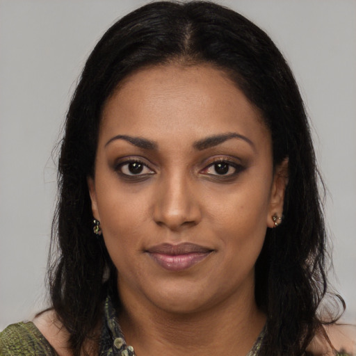 Joyful black young-adult female with long  black hair and brown eyes