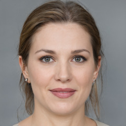 Joyful white young-adult female with medium  brown hair and grey eyes