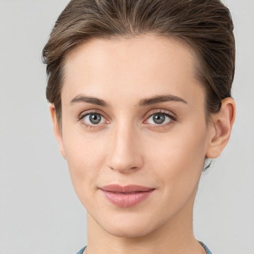 Joyful white young-adult female with short  brown hair and grey eyes