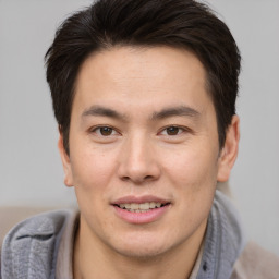 Joyful asian young-adult male with short  brown hair and brown eyes