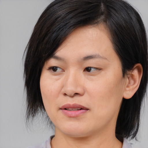 Joyful asian young-adult female with medium  black hair and brown eyes