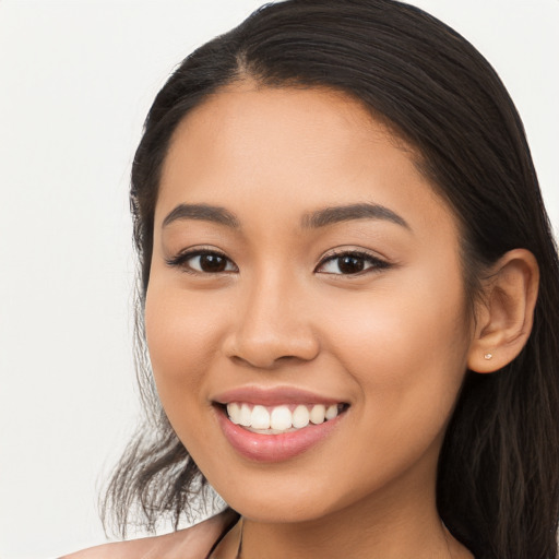 Joyful latino young-adult female with long  brown hair and brown eyes