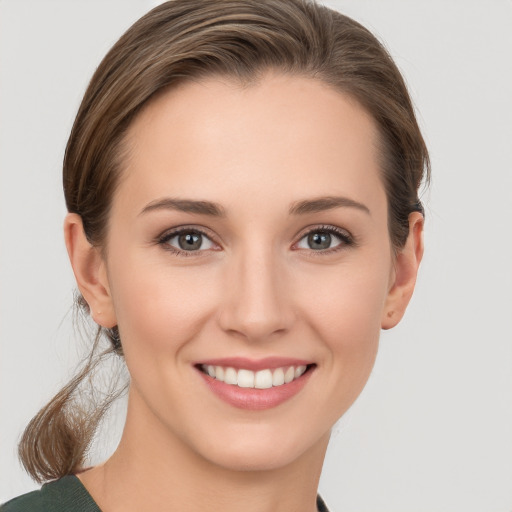 Joyful white young-adult female with medium  brown hair and grey eyes