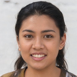 Joyful latino young-adult female with medium  brown hair and brown eyes