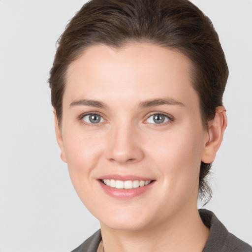 Joyful white young-adult female with short  brown hair and grey eyes