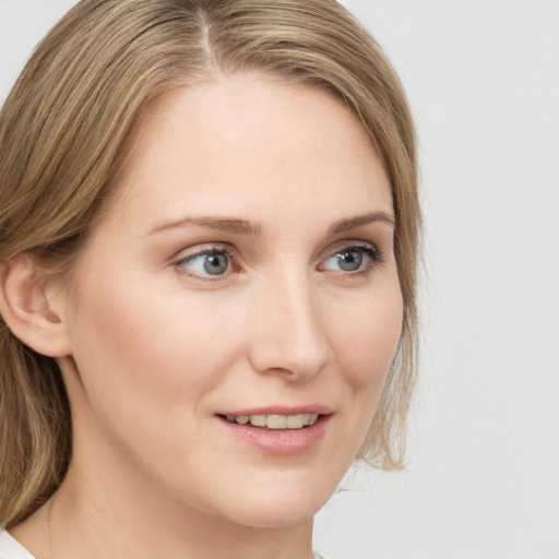 Joyful white young-adult female with medium  brown hair and green eyes