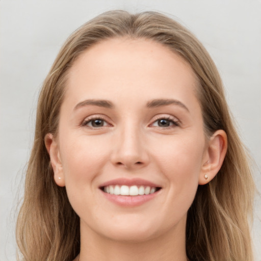 Joyful white young-adult female with long  brown hair and grey eyes