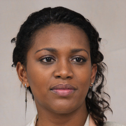 Joyful black young-adult female with medium  black hair and brown eyes