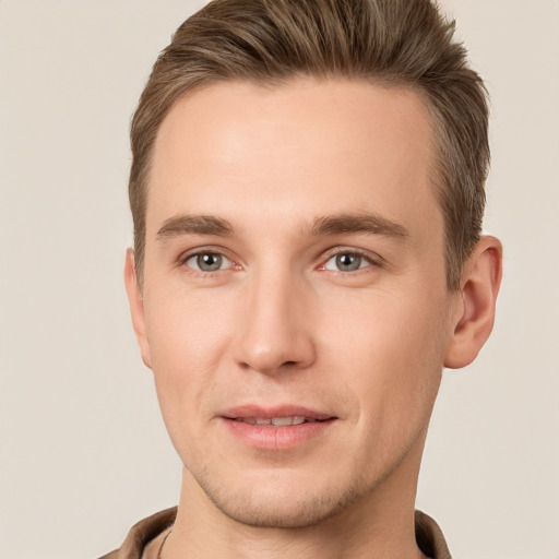 Joyful white young-adult male with short  brown hair and grey eyes