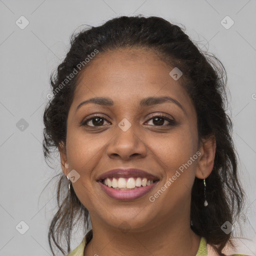 Joyful black young-adult female with long  brown hair and brown eyes