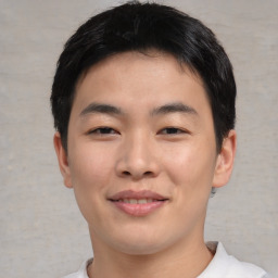 Joyful asian young-adult male with short  brown hair and brown eyes