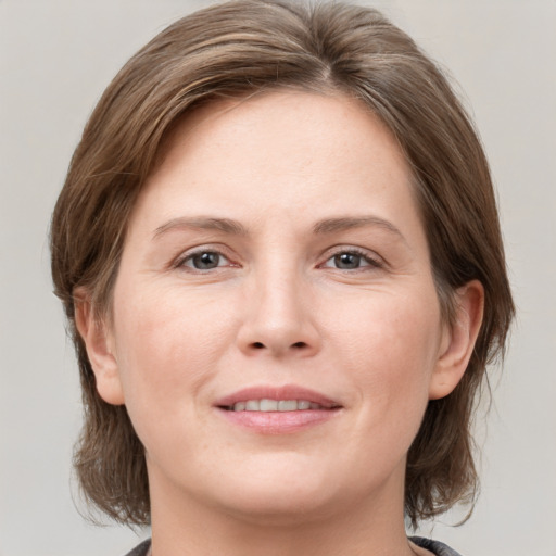 Joyful white adult female with medium  brown hair and grey eyes