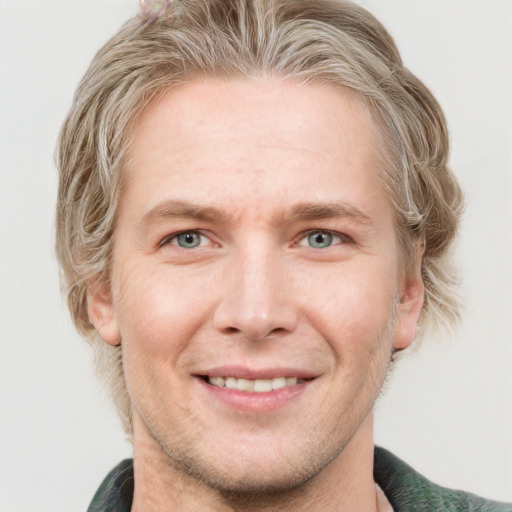 Joyful white adult male with short  brown hair and blue eyes