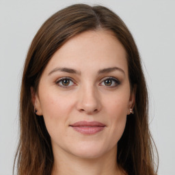 Joyful white young-adult female with long  brown hair and grey eyes