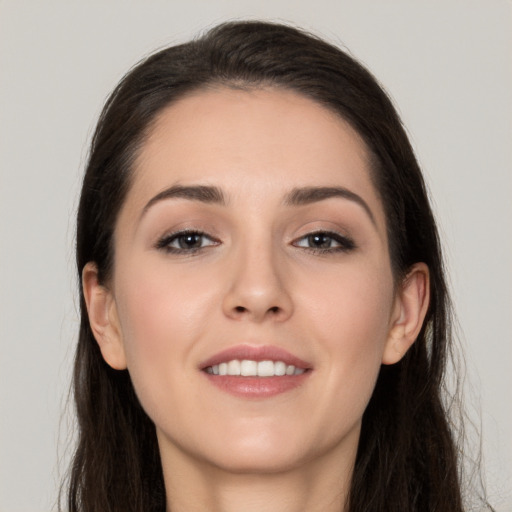 Joyful white young-adult female with long  brown hair and brown eyes