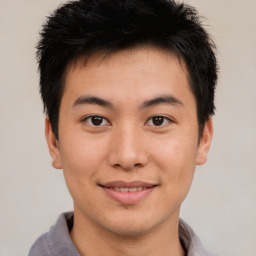 Joyful asian young-adult male with short  brown hair and brown eyes