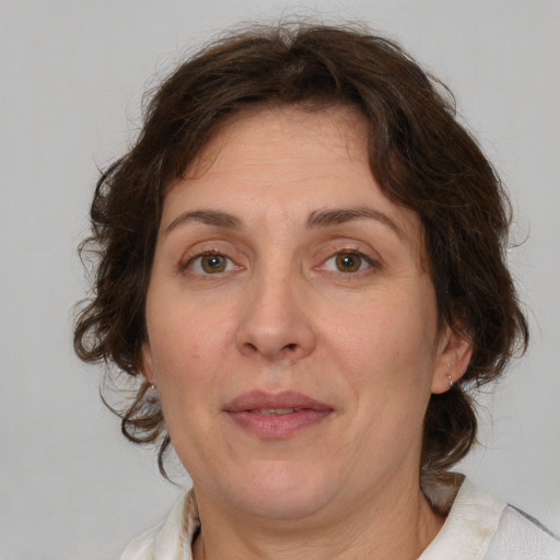 Joyful white adult female with medium  brown hair and green eyes