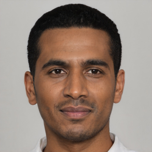 Joyful black young-adult male with short  black hair and brown eyes