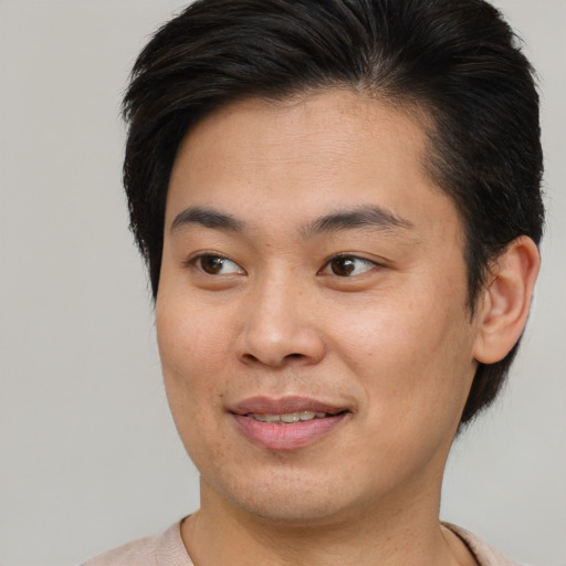 Joyful asian young-adult male with short  brown hair and brown eyes