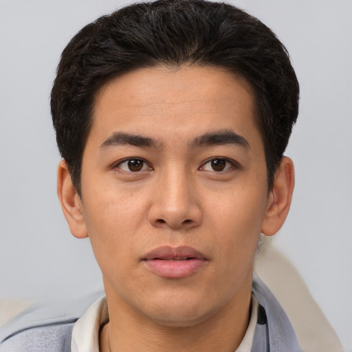 Joyful asian young-adult male with short  brown hair and brown eyes