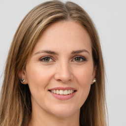 Joyful white young-adult female with long  brown hair and green eyes