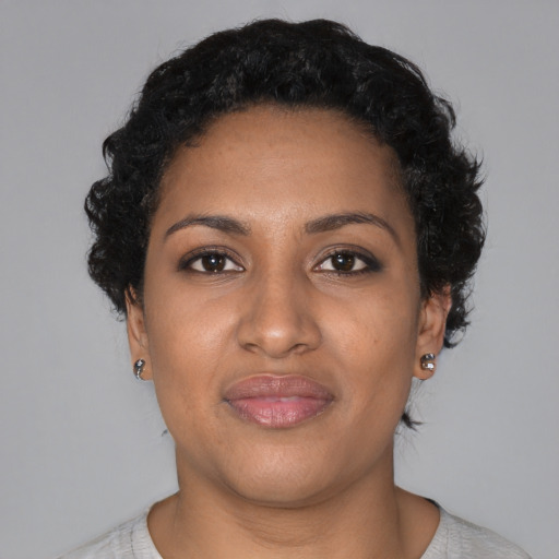 Joyful black young-adult female with short  black hair and brown eyes
