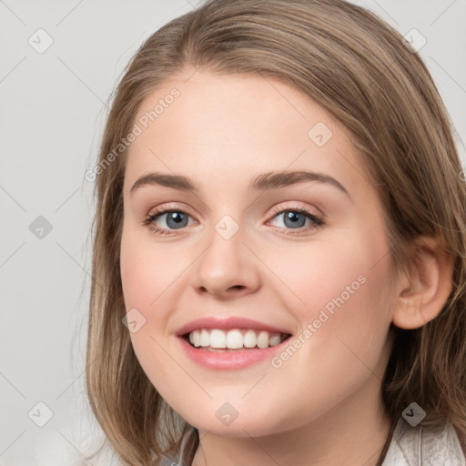 Joyful white young-adult female with long  brown hair and grey eyes