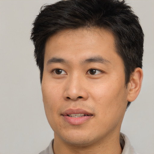 Joyful asian young-adult male with short  brown hair and brown eyes