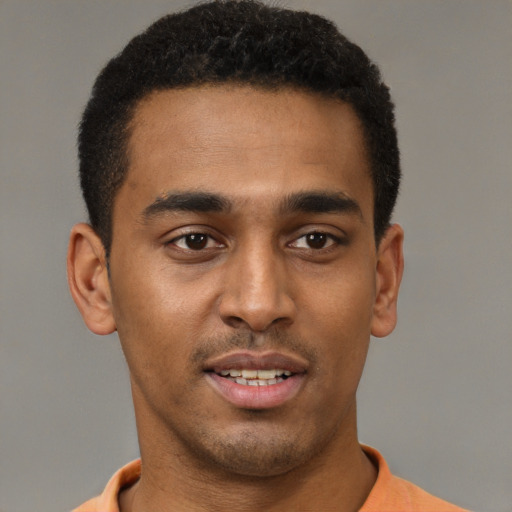 Joyful black young-adult male with short  brown hair and brown eyes