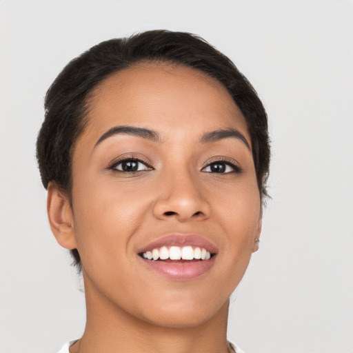 Joyful latino young-adult female with short  brown hair and brown eyes