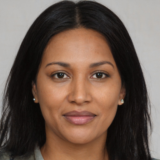 Joyful black adult female with long  black hair and brown eyes