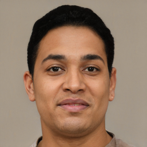 Joyful latino young-adult male with short  black hair and brown eyes