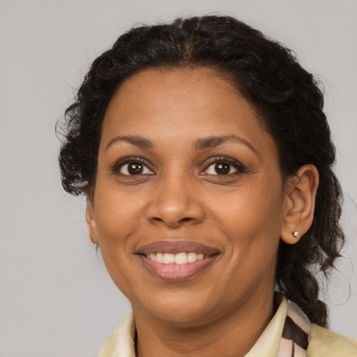 Joyful black adult female with medium  brown hair and brown eyes