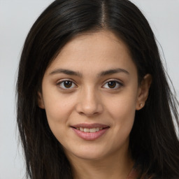 Joyful latino young-adult female with long  brown hair and brown eyes